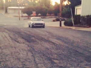 Even the dusty road holds a tale, The old car rolls by, carrying memories in its trail